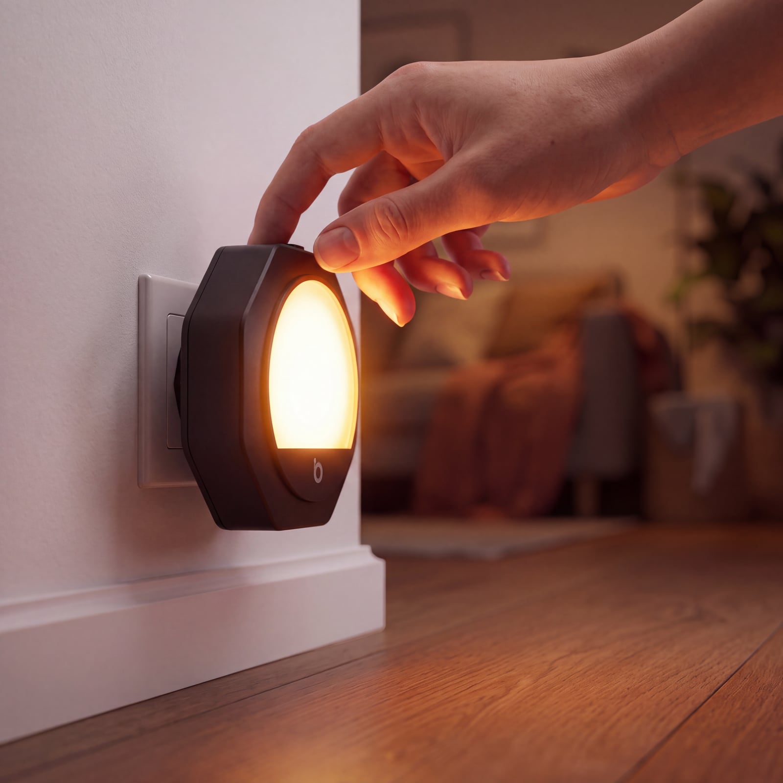 Main touchant le variateur d'une veilleuse ambre